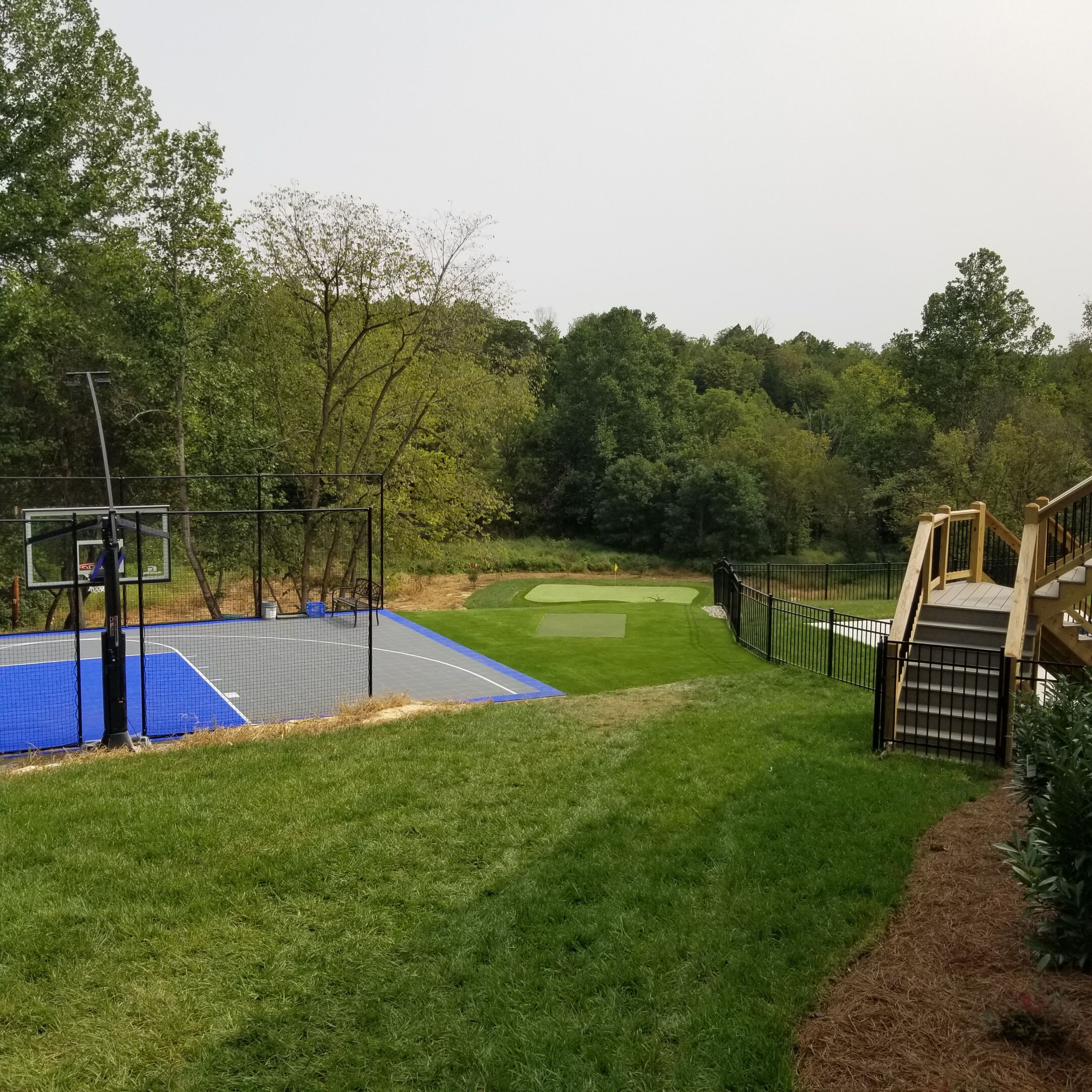 backyard golf green and basketball court